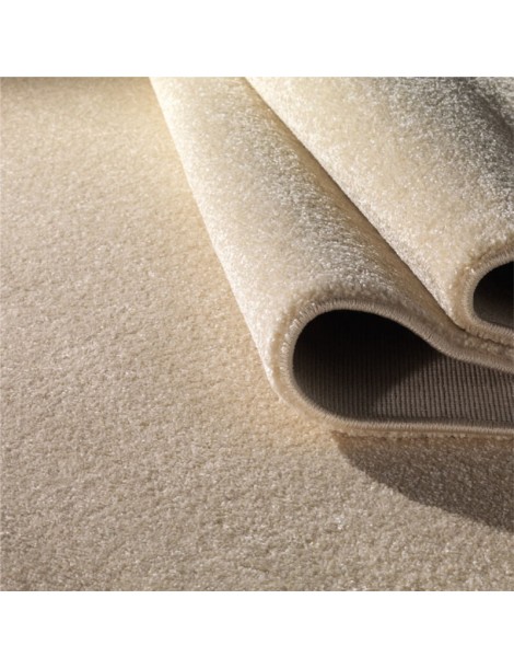 Dettaglio del tappeto minimalista a tinta piatta creama